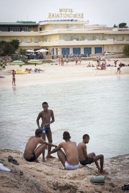 Cuatro inmigrantes, esta semana en una playa de Lampedusa.