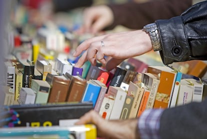 Varias personas escogen libros en una tienda de segunda mano.