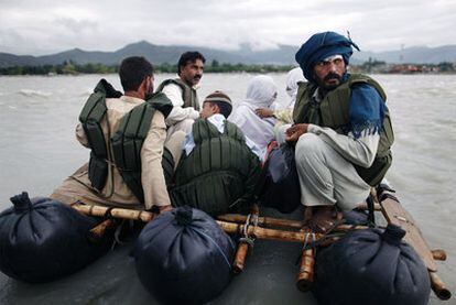 Habitantes de la localidad de Kanju, en el valle del Swat, usan una rudimentaria balsa, hecha de cámaras de neumáticos y bambú, para cruzar el río.