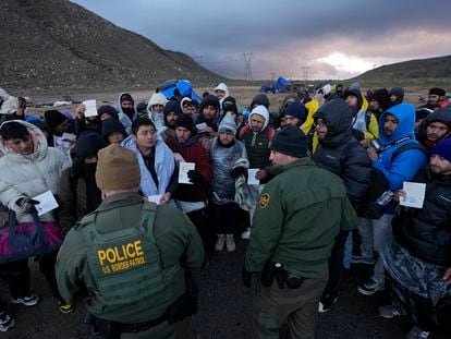 Migrantes en busca de asilo muestran sus papeles a dos agentes de la Patrulla Fronteriza, cerca de Jacumba (California), el 2 de febrero.