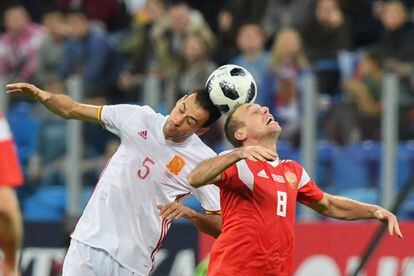 El jugador de la selección española, Sergio Busquets, y el jugador del combinado ruso, Denis Glushakov, tratan de hacerse con la posesión del balón en una acción del partido.