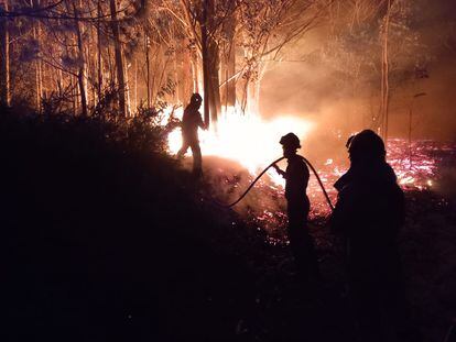 Miembros de la Unidad Militar de Emergencias (UME) intentan sofocar el fuego en la localidad asturiana de Navelgas, en la noche del viernes.