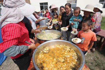 Varios trabajadores humanitarios sirven el almuerzo a algunas de las personas afectadas por un terremoto de magnitud 5.0 que dejó cinco heridos en el condado de Tonghai, en Yuxi, en la provincia suroccidental china de Yunnan, el pasado 14 de agosto de 2018.