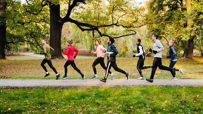 Un grupo de corredores compiten entre sí en un paseo peatonal en el parque.
