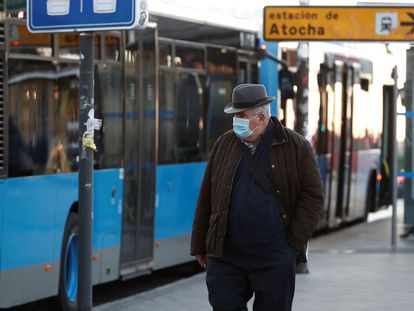Un hombre protegido con una mascarilla transita las inmediaciones de la estación de Atocha (Madrid) este lunes.