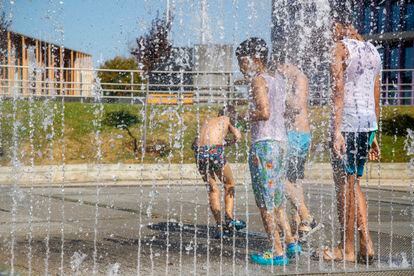 Varios niños se refrescan en una fuente de Zaragoza, para intentar sofocar las altas temperaturas registradas este jueves. 