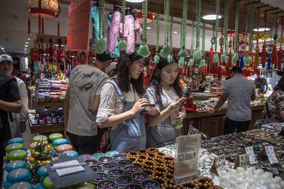 Ciudadanos chinos visitan una tienda en el distrito comercial de Wangfujing, en Pek&iacute;n.