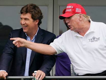 Tucker Carlson y Donald Trump charlan durante un torneo de Golf en julio de 2022.