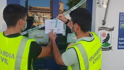 Agentes de la Guardia Civil precintan el establecimiento de lotería en El Cuervo que los Panecito adquirieron para blanquear.
