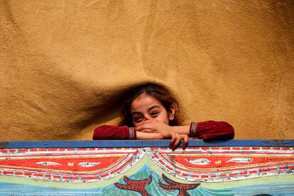 Una niña afgana sonríe a bordo de un camión mientras se prepara para salir hacia su país de origen, apenas un día antes de que expire el plazo que dio Pakistán. La imagen ha sido tomada este lunes en el campamento de refugiados y centro de repatriación del ACNUR en Nowshera (Pakistán).