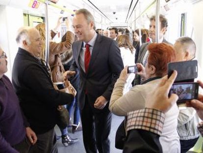El jefe del Consell, Alberto Fabra, saluda a los viajeros del nuevo tramo de metro de Valencia.