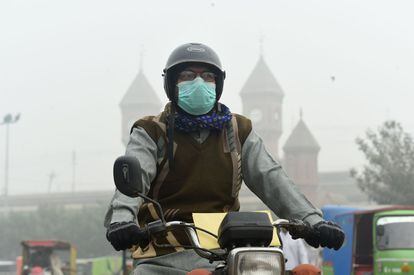 En Pakistán, la ciudad de Lahore estaba también envuelta en una niebla contaminada, que provoca masivas hospitalizaciones, vuelos anulados, y horarios cambiados en las escuelas. En la foto, un hombre circula con mascarilla por una calle de Lahore (Pakistán).