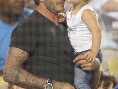 Harper Beckham besa a su padre durante un partido de b&eacute;isbol, el 27 de agosto de 2013.