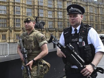 Un soldado británico y un policía patrullan por los alrededores del Parlamento de Londres.