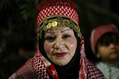 Una mujer observa las celebraciones nocturnas en las calles de Amán el día de la boda real del príncipe heredero.