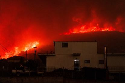 Un incendio forestal quema un bosque cerca de una casa en el pueblo de Avantas (Grecia), el lunes.