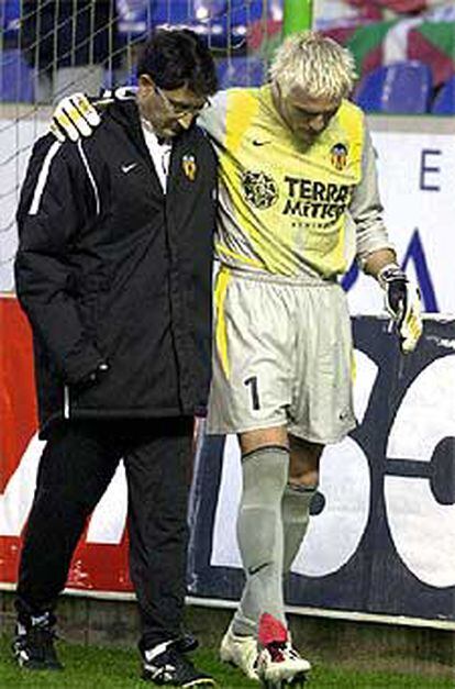 Cañizares se retira lesionado acompañado por el doctor del Valencia.