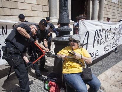 Mossos rompen la cadena que ata a una mujer frente a la Generalitat este viernes.