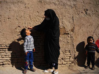 Una mujer administra gotas de la vacuna contra la polio a un niño, en Herat (Afganistán).