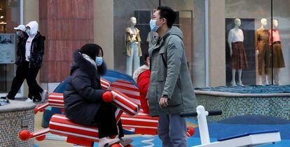 Personas con mascarillas protectoras en un centro comercial de Pekín. 