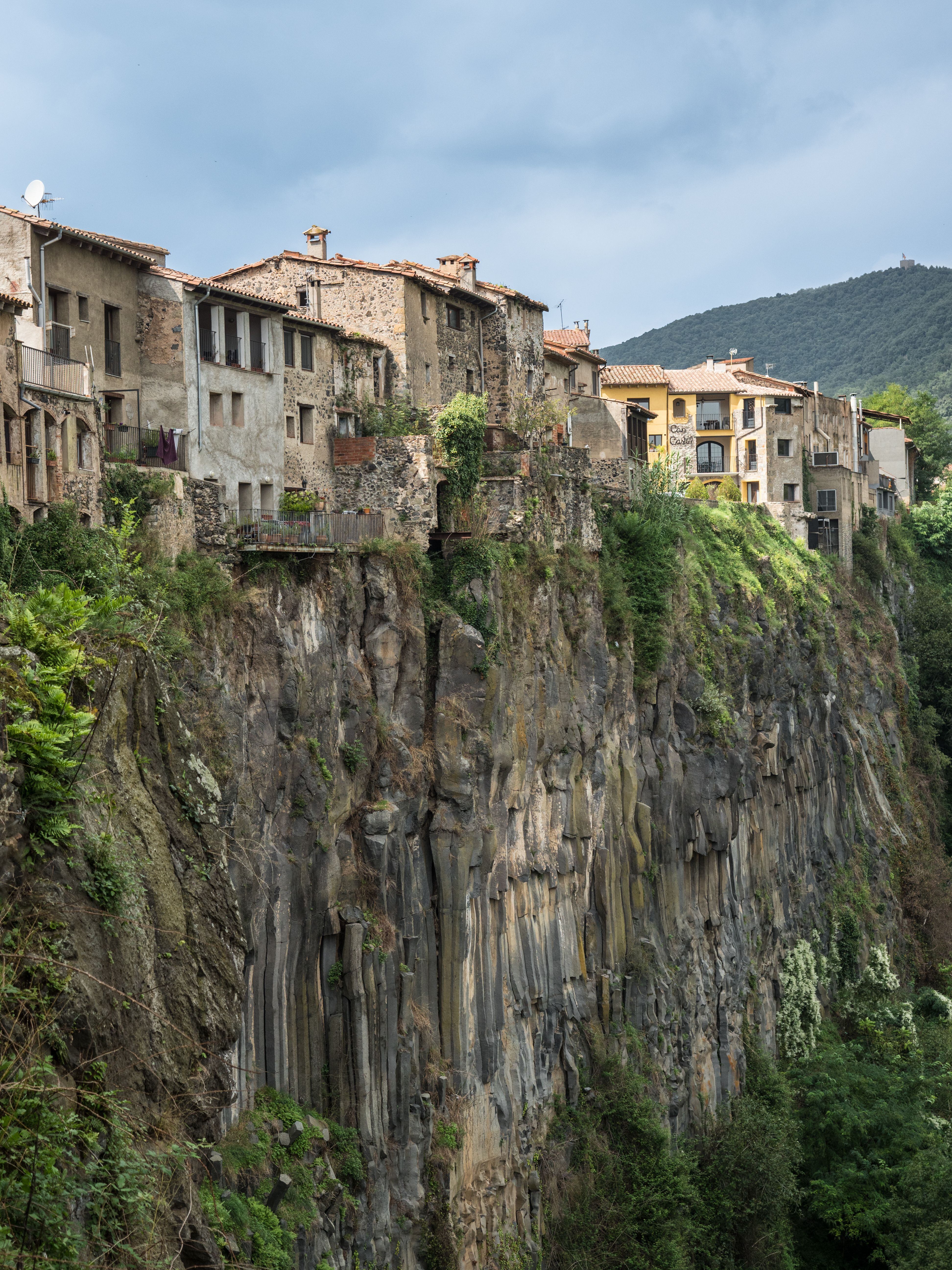 Vista vertical de una hilera de casas sobre un acantilado de basalto en el pueblo de Castellfolit de la Roca.