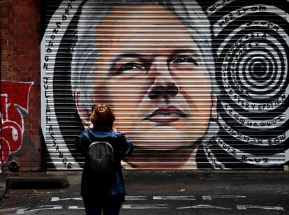 Una mujer observa un mural con el rostro del periodista Julian Assange en las calles de Melbourne.