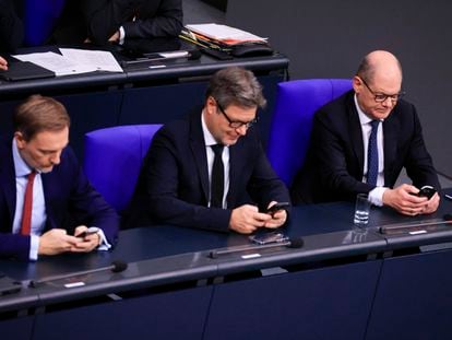 Los ministros alemanes de finanzas y economía, Christian Lindner y Robert Habeck, junto al canciller Olaf Scholz, revisan sus móviles en el Bundestag en Berlín, el pasado 13 de diciembre.