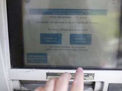 Información sobre la comisión de dos euros en cajero automático en una oficina bancaria de CaixaBank.