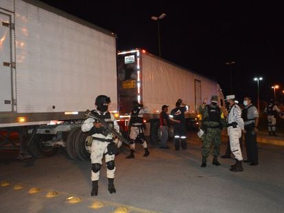 Miembros de la Guardia Nacional custodian los tres camiones en los que viajaban los migrantes.