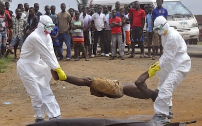 Los equipos sanitarios retiran, en Monrovia, el cuerpo de un hombre sospechoso de ébola.