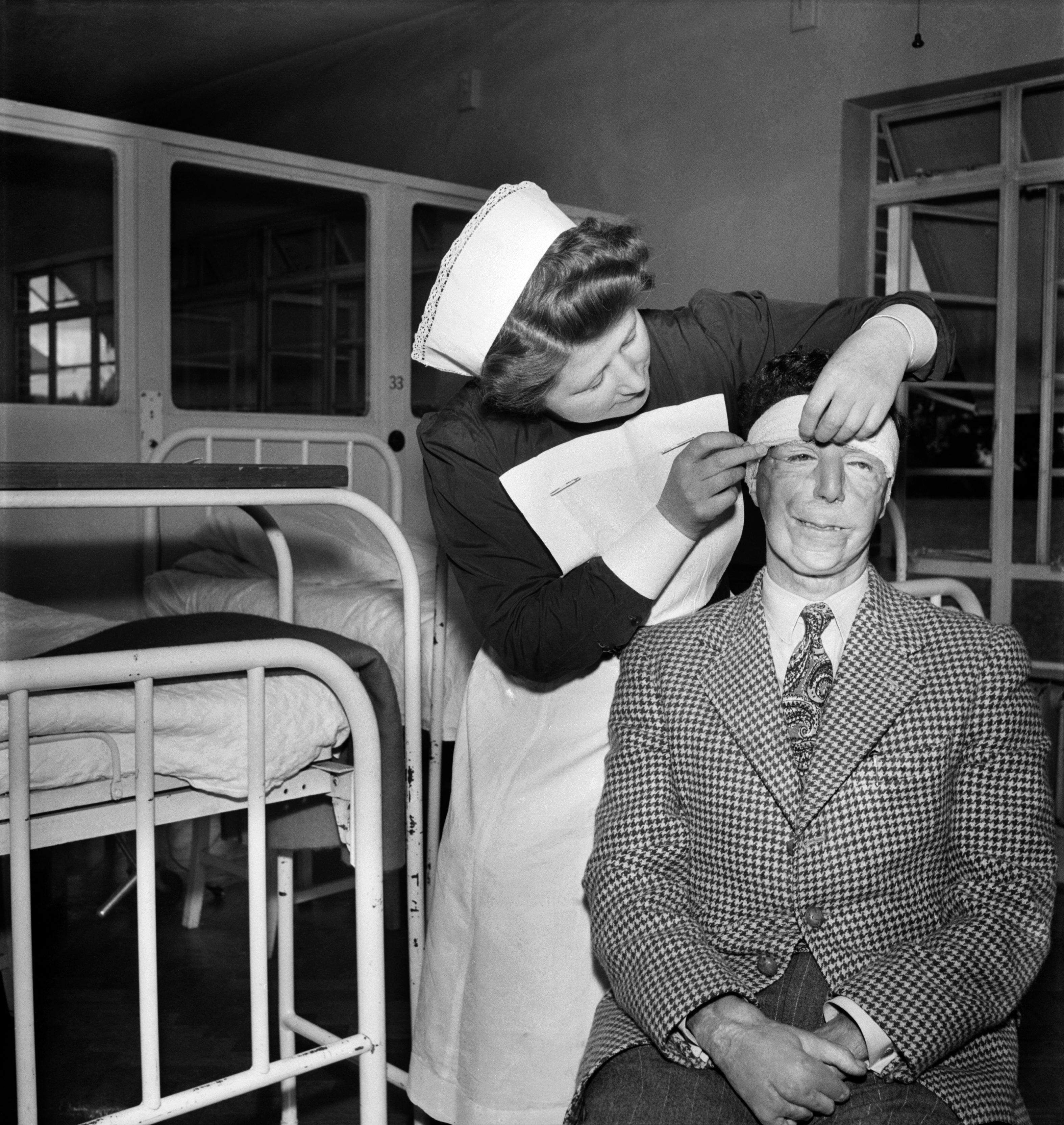 Una enfermera atiende a un excombatiente de la Segunda Guerra Mundial en un hospital de Sussex. Él es uno de los miembros del 'Guinea Pig Club'.