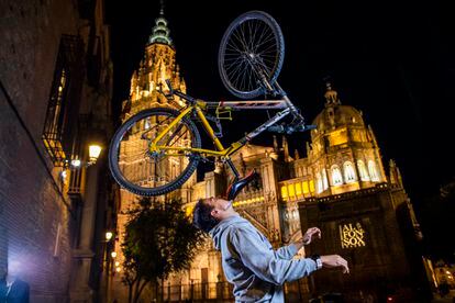 Christian López, con 95 récords Guiness, sostiene una bicicleta con su barbilla en la plaza del Ayuntamiento de Toledo.