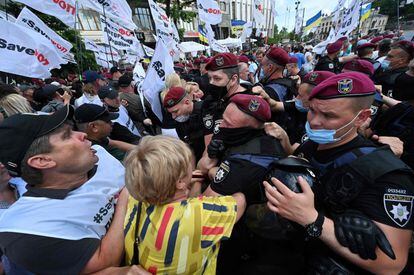 Un grupo de pequeños empresarios se enfrenta a la policía durante una marcha contra el presidente ucraniano para pedir la derogación de las modificaciones de una ley sobre el sistema tributario simplificado, en Kiev, Ucrania.