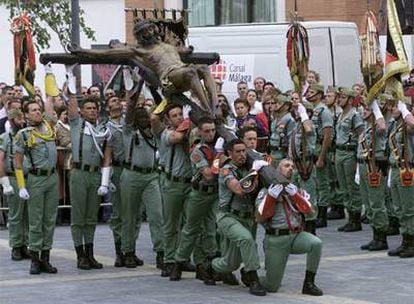 Legionarios en el desprendimiento del Cristo de la Buena Muerte para su procesión en Málaga.