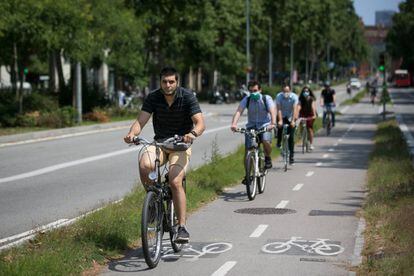Varias personas se mueven en bicicleta por un carril bici de Barcelona. 