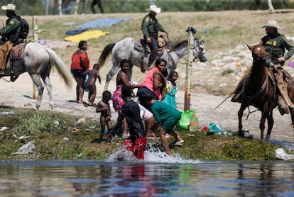 Agentes de la patrulla fronteriza de Estados Unidos cortan el paso a migrantes solicitantes de asilo que intentan regresar a Estados Unidos por el río Grande.