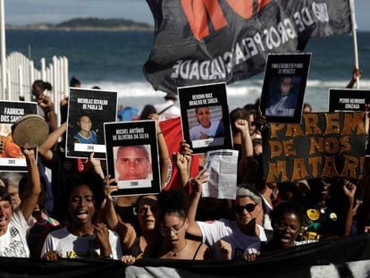 Habitantes de las favelas de Río muestran fotos de víctimas de violencia mientras participan en una protesta cerca de la playa de Ipanema en Río de Janeiro, Brasil, el pasado 26 de mayo.
