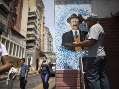 Venezuelan artist Mervin Marmol puts finishing touches on his painting of late Venezuelan Dr. Jose Gregorio Hernandez at the street corner where he died in a car accident in 1919 in La Pastora neighborhood in Caracas, Venezuela, Monday, April 26, 2021. Known as the