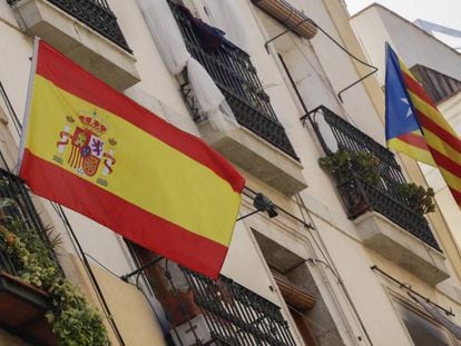 Bandera espa&ntilde;ola y bandera catalana estelada independentista en un edificio de Barcelona.