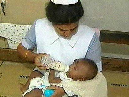 Una enfermera da el biberón al <i>Baby 81</i> en el hospital de Kalmunai.