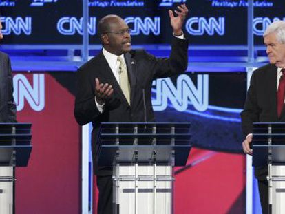 Mitt Romney (izquierda) y Newt Gingrich (derecha) escuchan a Herman Cain durante el debate.