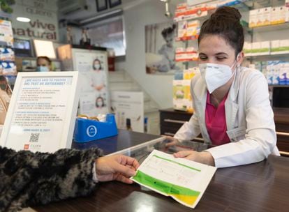 Una farmacéutica muestra un test de antígenos a una persona en la farmacia ‘Las Gemelas’, a 10 de enero de 2022, en Madrid.