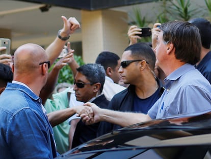 El presidente Bolsonaro estrecha la mano de un admirador este viernes en Brasilia.