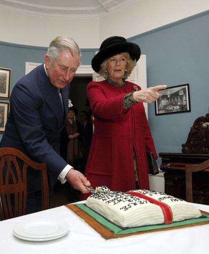 El príncipe Carlos de Inglaterra corta la tarta del bicentenario del nacimiento del Charles Dickens, junto a su esposa Camila, durante la visitia al museo londinense dedicado al escritor.