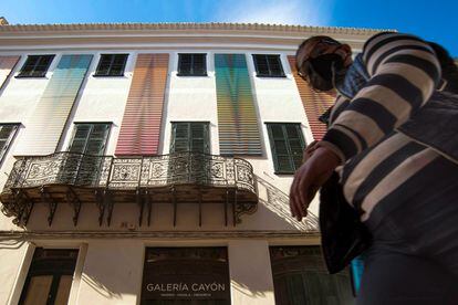 Un visitante observa la obra de seis metros de altura del artista venezolano Carlos Cruz Díez (Caracas 1923-París 2019), uno de los máximos exponentes del arte cinético y maestro del color, en la fachada de la Galería Cayón de Mahón (Menorca).