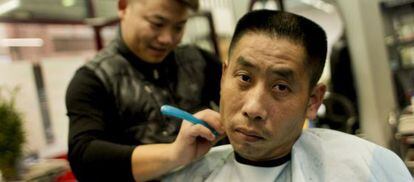 Un hombre se corta el pelo en una de las muchas peluquerías chinas de Usera.