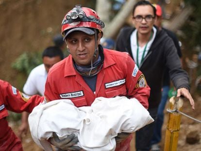 Un trabajador de rescate carga el cadáver de un niño.