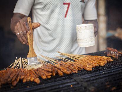 “Estoy aquí desde las 5.30 pm y hasta medianoche", comenta Abdou mientras impregna de aceite las brochetas en la parrilla que vende en las calles de Dakar. Las más populares son las de ternera, dice.