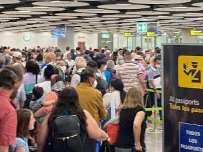 Decenas de viajeros esperando esta mañana en el control de pasaportes de Madrid-Barajas.