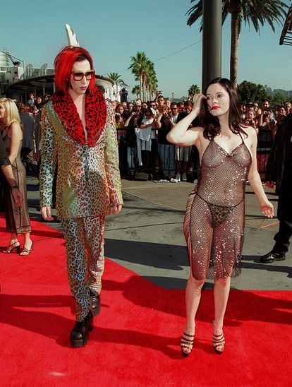 Las 'celebrities' de los años 90 recogieron la tendencia de las transparencias para llevárselo hacia su terreno y convertir esta osadía en una especie de declaración de intenciones protofeminista ("Este es mi cuerpo y hago con él lo que quiero") pero siempre sin perder el sentido del espectáculo. En esta imagen vemos a la actriz Rose McGowan llegando en 1998 a los MTV Video Awards, acompañada de su pareja de entonces, el cantante Marilyn Manson. Mac Gowan sería años después una de las grandes instigadoras del movimiento #MeToo.